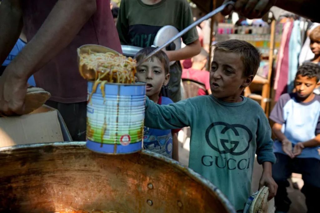 Seorang anak pengungsi mengantre untuk mendapatkan bantuan makanan di Deir el-Balah pada 17 Oktober 2024